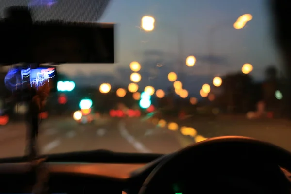 Vista strada notturna dall'interno auto strada luce naturale e altre auto è il movimento offuscata, immagine sfocata dall'interno di una macchina che viaggia di notte . — Foto Stock
