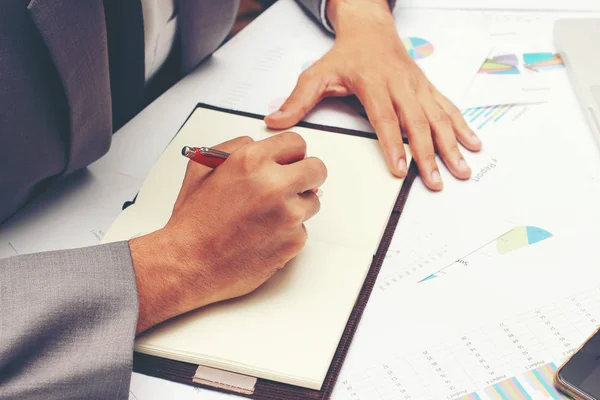 Empresário escrevendo um relatório de negócios sobre caderno em branco com caneta vermelha no escritório da mesa. .Conceito de negócio : — Fotografia de Stock