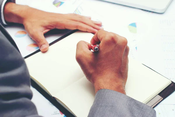 Empresário escrevendo um relatório de negócios sobre caderno em branco com caneta vermelha no escritório da mesa. .Conceito de negócio : — Fotografia de Stock