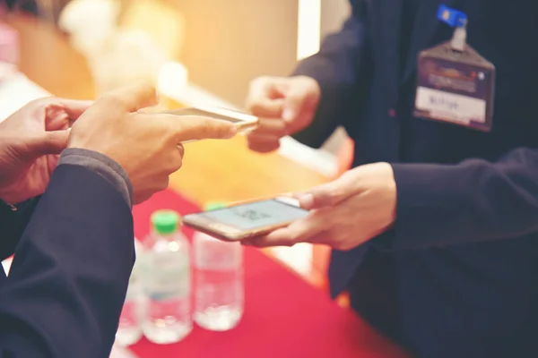 Education people hold cellphone in hands at information desk is sharing data for register the conference via smartphone. Modern communication technology, business presentation. — Stock Photo, Image