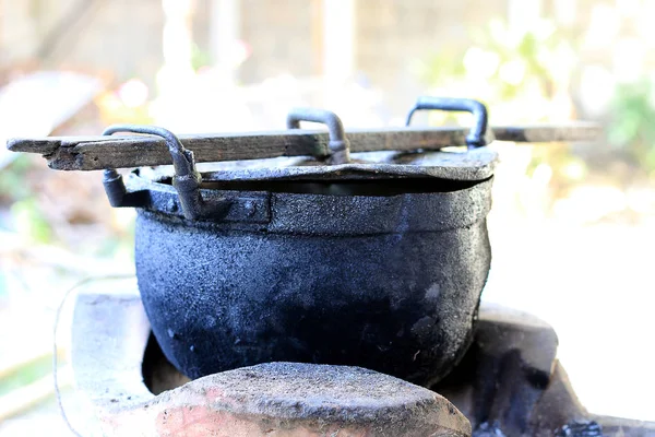 black pot and firewood for cooking in the north of thailand, old pot black color