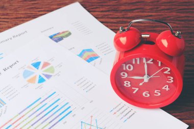 grafik ahşap arka plan üzerinde kırmızı saati. İş geçmişi, finans, vergi, muhasebe. Kavram uyanma vakti.