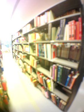 Kütüphanenin içindeki rafta çok farklı renkte eski kitaplar var.