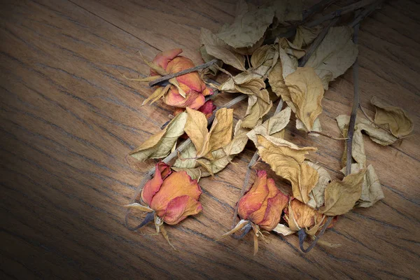 Vintage-Stillleben-Fotografie mit getrockneten Rosenblüten auf dem alten schönen hölzernen Hintergrund der gebeizten Planke. — Stockfoto