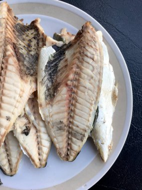 siyah arka plan üzerine beyaz tabak uskumru.