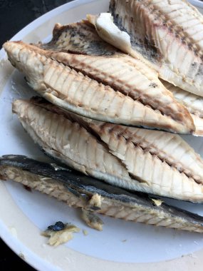 siyah arka plan üzerine beyaz tabak uskumru.