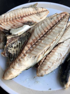 siyah arka plan üzerine beyaz tabak uskumru.