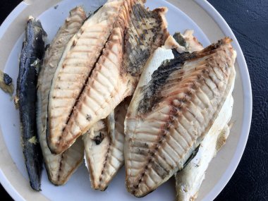 siyah arka plan üzerine beyaz tabak uskumru.