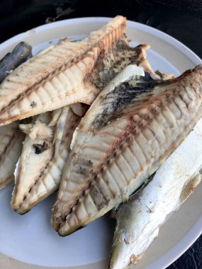 siyah arka plan üzerine beyaz tabak uskumru.