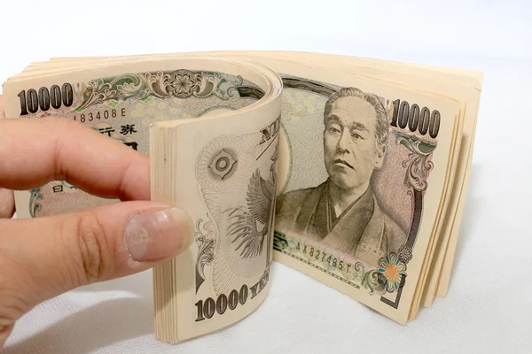 Mão contando dinheiro, nota de moeda japonesa, iene japonês no fundo branco . — Fotografia de Stock