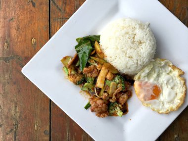 kavrulmuş chili Yapıştır ve tatlı fesleğen yaprağı, brokoli, mantar karışık sebze, kızarmış tavukla karıştırın kızarmış yumurta beyaz ahşap arka plan, gıda Tay tabakta Yasemin pirinç.