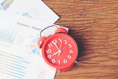 grafik ahşap arka plan üzerinde kırmızı saati. İş geçmişi, finans, vergi, muhasebe. Kavram uyanma vakti.