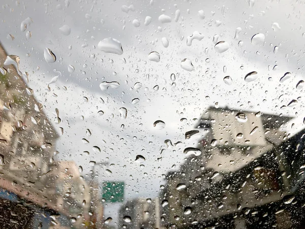 soft focus of Water drops on car glass with traffic jam background, traffic jam in Songkran Festival day.