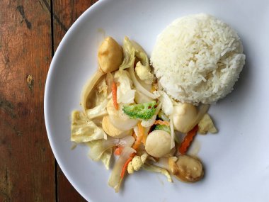 Kızarmış tofu sebze ile Tayland Yasemin pirinç ahşap arka plan üzerinde beyaz tabak ile. Gıda Tay tarzında. Vejetaryen yiyecekler.