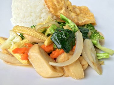 Ahşap arka plan beyaz bir tabağa omlet ile kızartma sebze ilave edin. Tay tarzı yiyecek. Vejetaryen yiyecekler