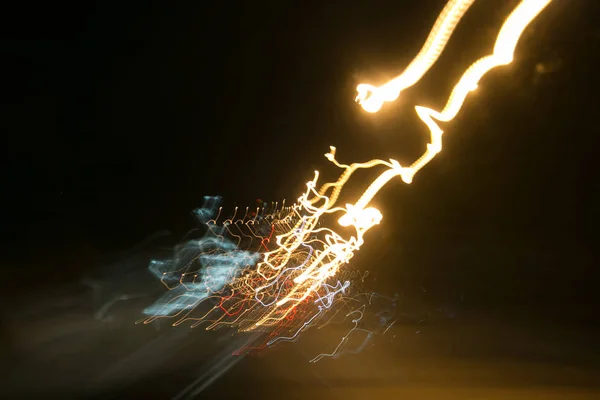 Street lights in speeding car in night time, light motion with slow speed shutter view from inside front of car. — Stock Photo, Image