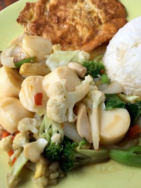 Kızarmış tofu sebze ve ahşap masa üzerinde yeşil tabak içinde Tay omlet (yumurta). Gıda Tay tarzında. Vejetaryen yiyecekler. Vintage sesi.