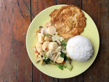 Kızarmış tofu sebze ve ahşap masa üzerinde yeşil tabak içinde Tay omlet (yumurta). Gıda Tay tarzında. Vejetaryen yiyecekler. Vintage sesi.
