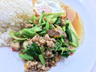 Kızarmış Çince lahana filiz gevrek domuz eti ile beyaz arka plan üzerinde beyaz tabak ilave edin. Tayland Gıda