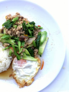 Kızarmış Çince lahana filiz gevrek domuz eti ile beyaz arka plan üzerinde beyaz tabak ilave edin. Tayland Gıda