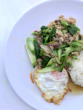 Kızarmış Çince lahana filiz gevrek domuz eti ile beyaz arka plan üzerinde beyaz tabak ilave edin. Tayland Gıda