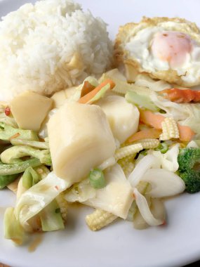 Tofu ve ahşap arka plan üzerinde beyaz tabak pirinç kızarmış yumurta ile tavada kızartılmış karışık sebze. Vejetaryen yiyecekler, sağlıklı gıda.