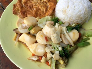 Kızarmış tofu sebze ve ahşap masa üzerinde yeşil tabak içinde Tay omlet (yumurta). Gıda Tay tarzında. Vejetaryen yiyecekler. Vintage sesi.