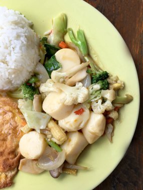 Kızarmış tofu sebze ve ahşap masa üzerinde yeşil tabak içinde Tay omlet (yumurta). Gıda Tay tarzında. Vejetaryen yiyecekler. Vintage sesi.