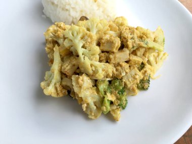 Tofu ve ahşap masa üzerinde beyaz pate yumurta ile kızarmış karnabahar.