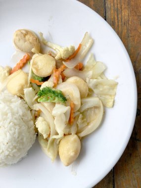 Kızarmış tofu sebze ile Tayland Yasemin pirinç ahşap arka plan üzerinde beyaz tabak ile. Gıda Tay tarzında. Vejetaryen yiyecekler.