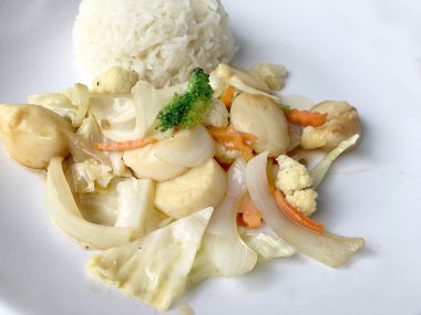 Kızarmış tofu sebze ile Tayland Yasemin pirinç ahşap arka plan üzerinde beyaz tabak ile. Gıda Tay tarzında. Vejetaryen yiyecekler.