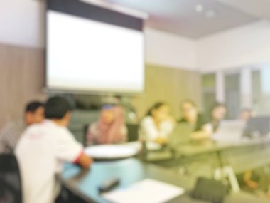 Arka plan bulanık görüntü okuyan öğrenciler ve iş soyut ve büyük salonu meslek seminer ekran ve bilgi göstermek için projektör ile tartışmak.