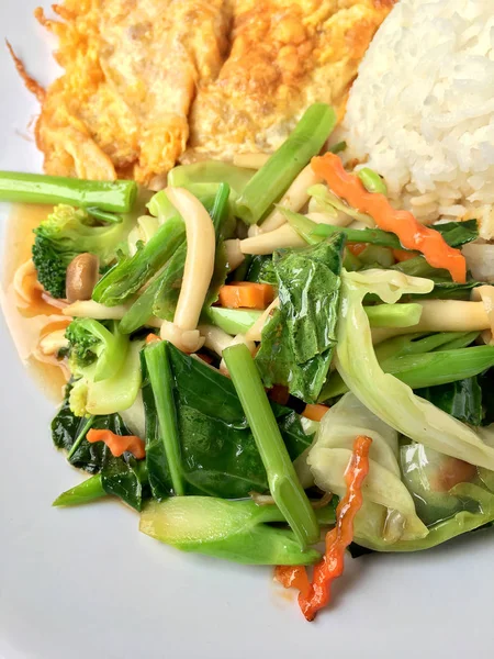 Stir fried vegetables with Thai Omelette (scrambled eggs) with rice in white plate on rustic wooden background. Vegetarian Food, healthy food. — Stock Photo, Image