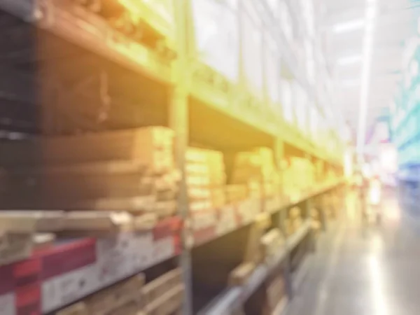 blurred image of people shopping in at hardware store or storehouse with variety of indoor & outdoor ceiling fans, flushmount,recessed,track lights, led. vintage tone with light effect.