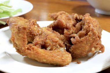 Baharatlı derin kızartma tava tavuk kanadı beyaz tabak yemek için masaya.