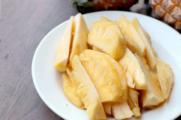 Dělení čerstvý ananas a ananas skořápky asijského stylu v bílé misce na staré dřevěné pozadí. Tropické ovoce concept. — Stock fotografie