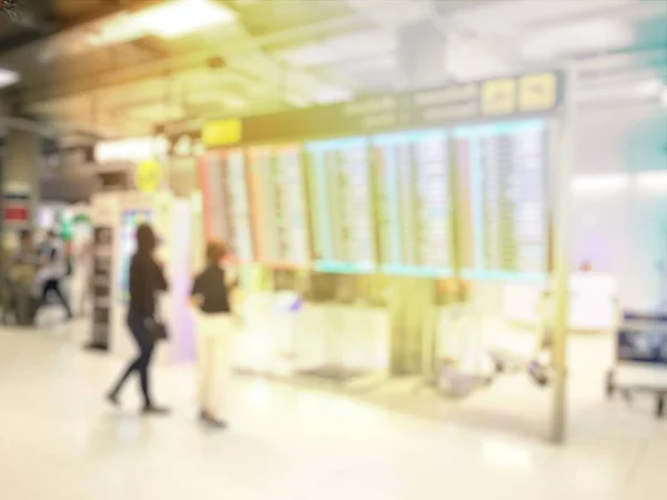 Blurred people in airport hall waiting for flight near plane board