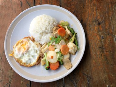 kızarmış sebze tofu karışık pirinç ve ahşap arka plan üzerinde beyaz tabak kızarmış yumurta. Vejetaryen yiyecekler, sağlıklı gıda.