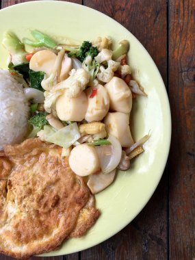 Kızarmış tofu sebze ve ahşap masa üzerinde yeşil tabak içinde Tay omlet (yumurta). Gıda Tay tarzında. Vejetaryen yiyecekler. Vintage sesi.