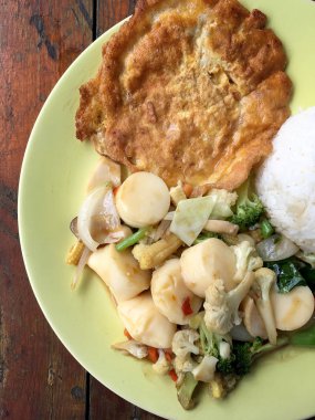 Kızarmış tofu sebze ve ahşap masa üzerinde yeşil tabak içinde Tay omlet (yumurta). Gıda Tay tarzında. Vejetaryen yiyecekler. Vintage sesi.