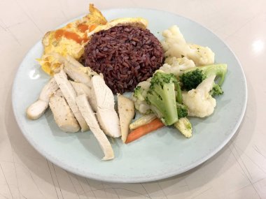 Temiz gıda, Riceberry pirinç haşlanmış tavuk, havuç ile ile diğer vegetableand freied yumurta tometo. Kantin veya gıda mahkeme arka plan bulanıklık ile beyaz tabak içinde sağlık için iyi.