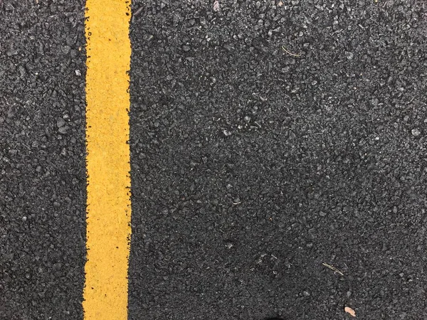黒いアスファルト道路の表面性状に黄色塗装ライン スペース交通機関の背景 — ストック写真