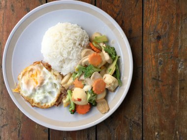 kızarmış sebze tofu karışık pirinç ve ahşap arka plan üzerinde beyaz tabak kızarmış yumurta. Vejetaryen yiyecekler, sağlıklı gıda.