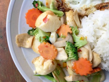 kızarmış sebze tofu karışık pirinç ve ahşap arka plan üzerinde beyaz tabak kızarmış yumurta. Vejetaryen yiyecekler, sağlıklı gıda.