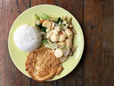 Kızarmış tofu sebze ve ahşap masa üzerinde yeşil tabak içinde Tay omlet (yumurta). Gıda Tay tarzında. Vejetaryen yiyecekler. Vintage sesi.