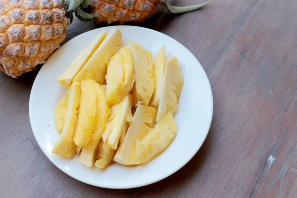 Dělení čerstvý ananas a ananas skořápky asijského stylu v bílé misce na staré dřevěné pozadí. Tropické ovoce concept. — Stock fotografie