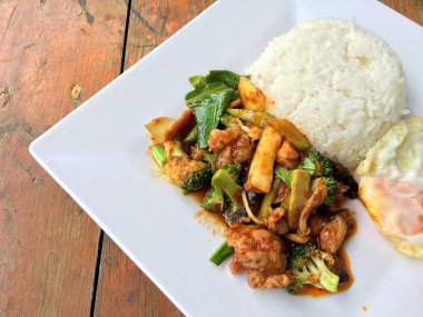 kavrulmuş chili Yapıştır ve tatlı fesleğen yaprağı, brokoli, mantar karışık sebze, kızarmış tavukla karıştırın kızarmış yumurta beyaz ahşap arka plan, gıda Tay tabakta Yasemin pirinç.