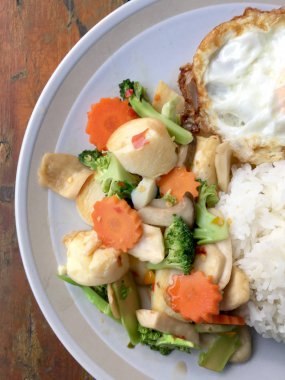 kızarmış sebze tofu karışık pirinç ve ahşap arka plan üzerinde beyaz tabak kızarmış yumurta. Vejetaryen yiyecekler, sağlıklı gıda.