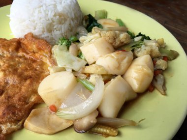 Kızarmış tofu sebze ve ahşap masa üzerinde yeşil tabak içinde Tay omlet (yumurta). Gıda Tay tarzında. Vejetaryen yiyecekler. Vintage sesi.