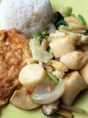 Kızarmış tofu sebze ve ahşap masa üzerinde yeşil tabak içinde Tay omlet (yumurta). Gıda Tay tarzında. Vejetaryen yiyecekler. Vintage sesi.